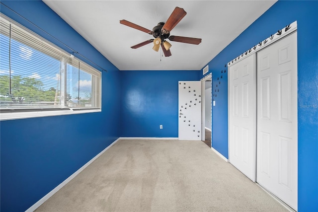 unfurnished bedroom with ceiling fan, carpet floors, a closet, and baseboards