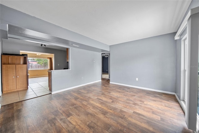 empty room with baseboards and wood finished floors