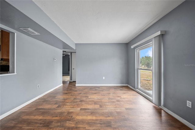 empty room featuring baseboards, visible vents, and wood finished floors