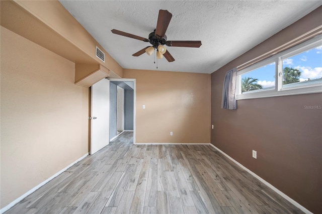 unfurnished room featuring a ceiling fan, baseboards, visible vents, and wood finished floors