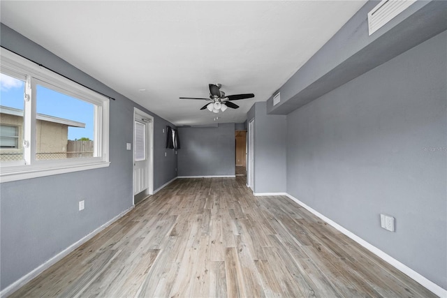 unfurnished living room with baseboards, a ceiling fan, visible vents, and wood finished floors