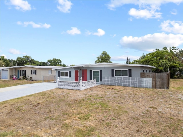 view of front of house with concrete driveway, a front yard, stucco siding, and fence