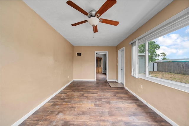 unfurnished room with baseboards, a ceiling fan, and wood finished floors