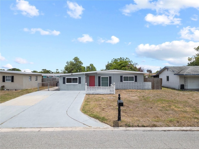 ranch-style house with concrete driveway, fence, and an attached carport