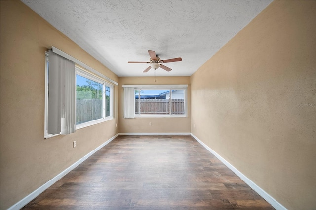 unfurnished room with a textured ceiling, baseboards, wood finished floors, and a ceiling fan