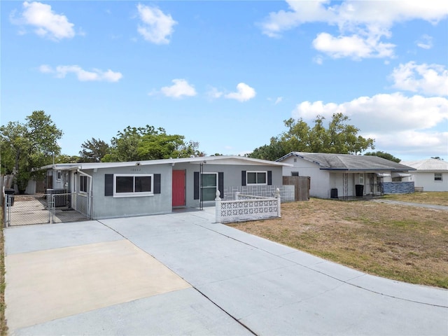 ranch-style house with driveway, a front lawn, fence, and a gate