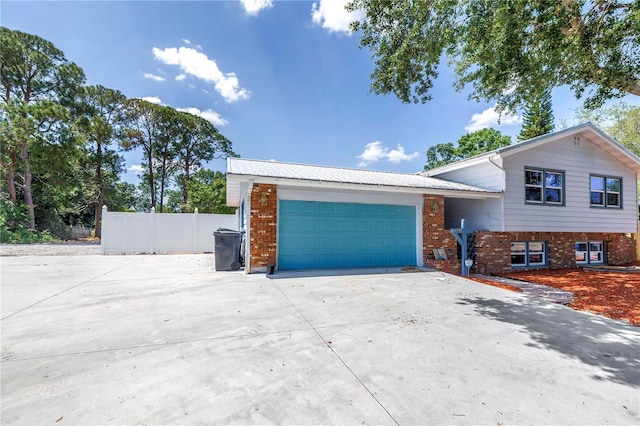 6515 Dimarco Rd, Tampa, FL 33634 - view of front of house with concrete driveway, an attached garage, fence, and brick siding