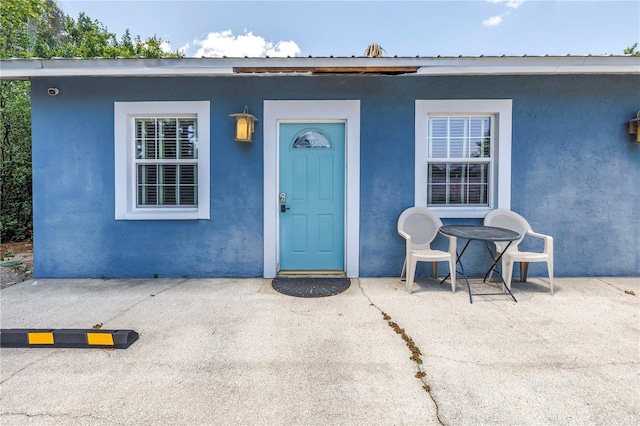 6515 Dimarco Rd, Tampa, FL 33634 - entrance to property with stucco siding and a patio