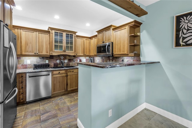 6515 Dimarco Rd, Tampa, FL 33634 - kitchen with appliances with stainless steel finishes, a sink, dark stone countertops, tasteful backsplash, and glass insert cabinets