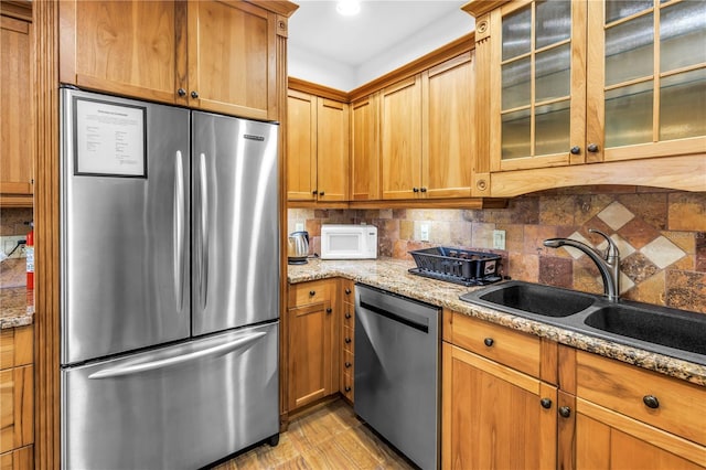 6515 Dimarco Rd, Tampa, FL 33634 - kitchen with appliances with stainless steel finishes, a sink, backsplash, light stone countertops, and glass insert cabinets