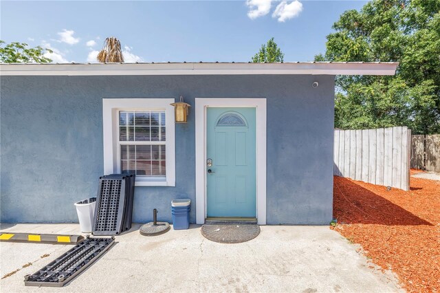 6515 Dimarco Rd, Tampa, FL 33634 - view of exterior entry with stucco siding and fence