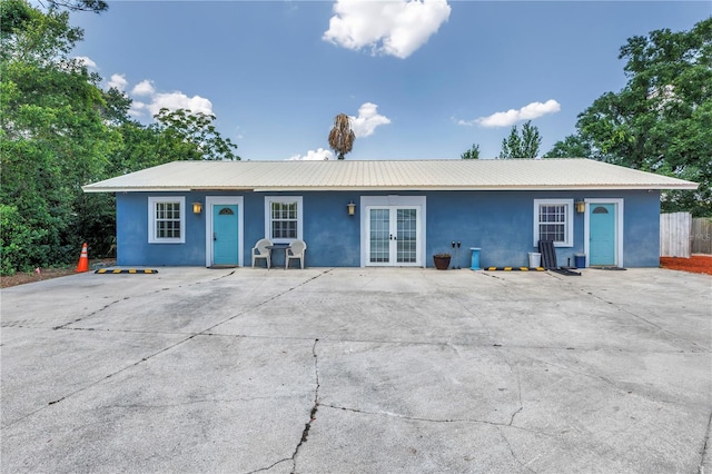 6515 Dimarco Rd, Tampa, FL 33634 - ranch-style house featuring french doors, stucco siding, and metal roof