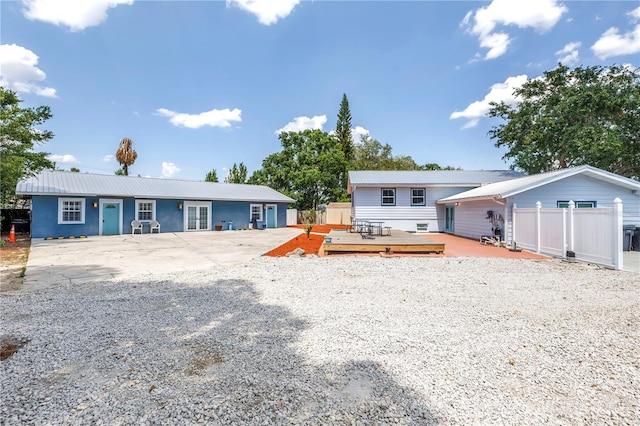 6515 Dimarco Rd, Tampa, FL 33634 - rear view of property with fence, a wooden deck, and metal roof
