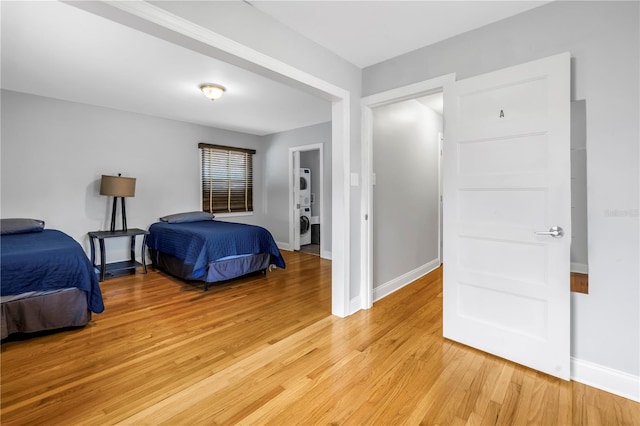 6515 Dimarco Rd, Tampa, FL 33634 - bedroom with stacked washer / dryer, light wood-style flooring, and baseboards
