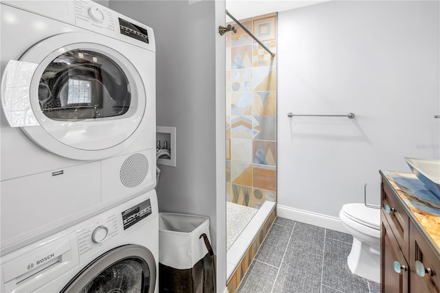 6515 Dimarco Rd, Tampa, FL 33634 - full bath with stacked washer / dryer, a tile shower, toilet, vanity, and tile patterned floors