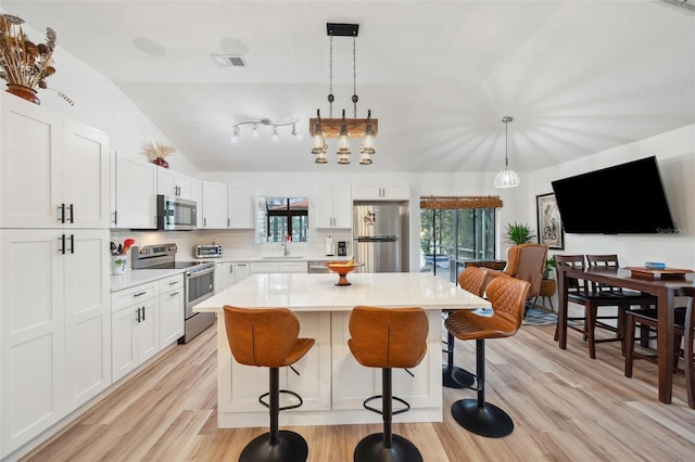 kitchen with a sink, stainless steel appliances, a breakfast bar area, and plenty of natural light