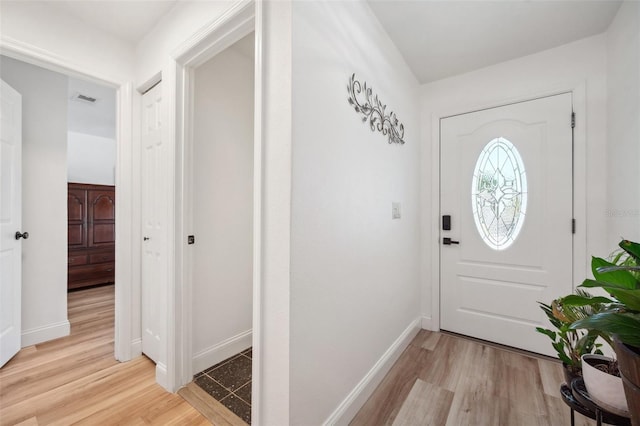 foyer featuring baseboards, light wood-style floors, and visible vents