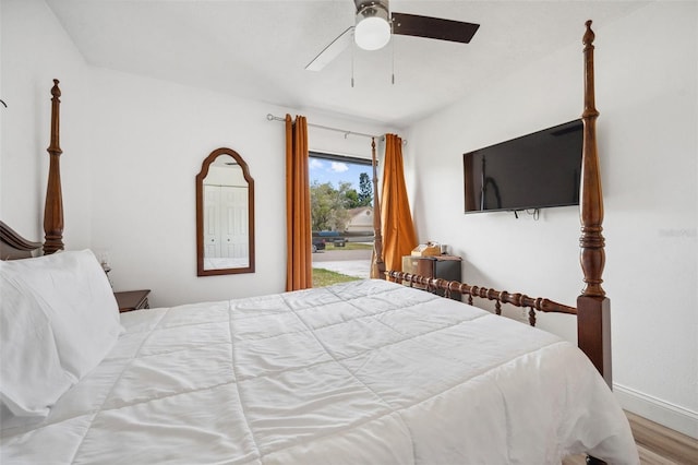 bedroom featuring baseboards, wood finished floors, and a ceiling fan
