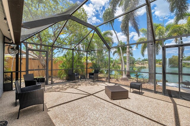 view of patio featuring a water view and glass enclosure