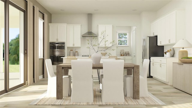6909 E 116th Ct, Palmetto, FL 34221 - kitchen with a center island, a wealth of natural light, wall chimney range hood, stainless steel appliances, and light wood-type flooring