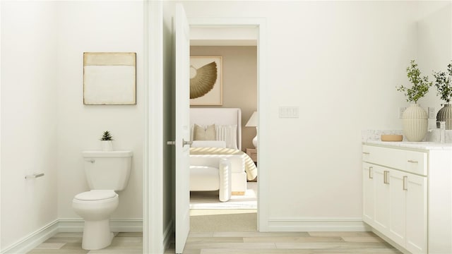 6909 E 116th Ct, Palmetto, FL 34221 - ensuite bathroom featuring baseboards, toilet, ensuite bath, vanity, and wood finished floors