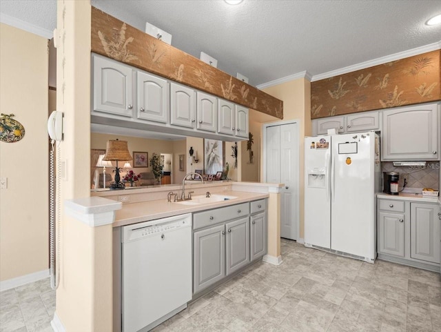 kitchen featuring white appliances, a sink, gray cabinetry, light countertops, and crown molding