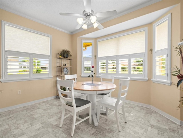 dining room with ornamental molding, a ceiling fan, baseboards, and a textured ceiling