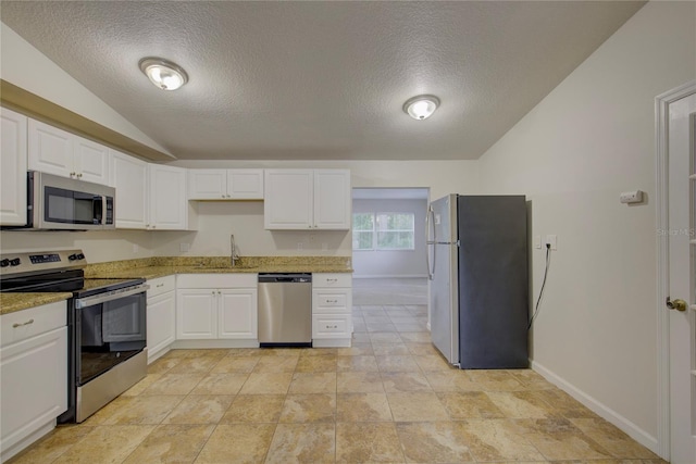 10319 Widgeon Way, New Port Richey, FL 34654 - kitchen with stainless steel appliances, a sink, vaulted ceiling, a textured ceiling, and baseboards