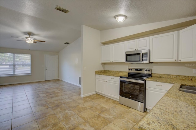 10319 Widgeon Way, New Port Richey, FL 34654 - kitchen with appliances with stainless steel finishes, vaulted ceiling, a textured ceiling, ceiling fan, and white cabinetry