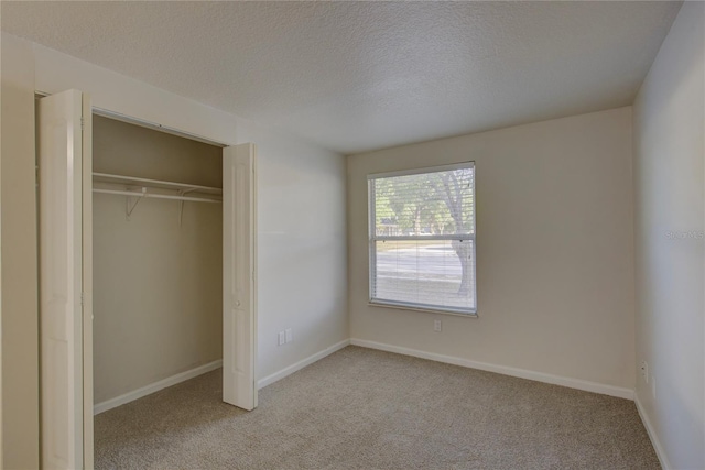 10319 Widgeon Way, New Port Richey, FL 34654 - unfurnished bedroom with carpet flooring, a textured ceiling, a closet, and baseboards