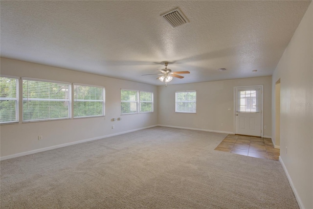 10319 Widgeon Way, New Port Richey, FL 34654 - spare room with light carpet, ceiling fan, healthy amount of natural light, baseboards, and a textured ceiling