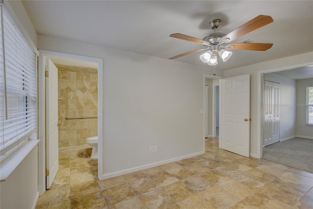 10319 Widgeon Way, New Port Richey, FL 34654 - unfurnished bedroom featuring baseboards, connected bathroom, a ceiling fan, and a closet