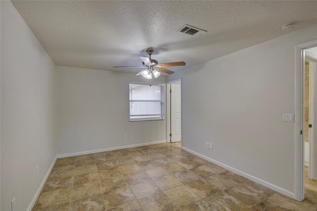 10319 Widgeon Way, New Port Richey, FL 34654 - unfurnished room featuring ceiling fan, baseboards, a smoke detector, a textured ceiling, and stone finish flooring
