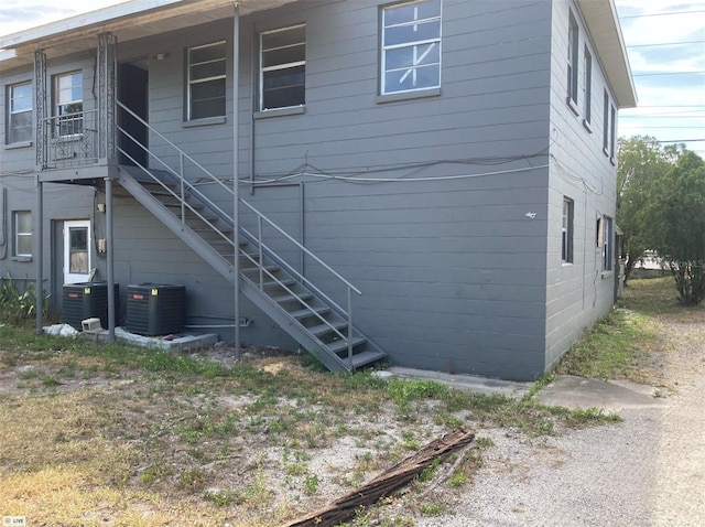 rear view of house with stairs and central air condition unit
