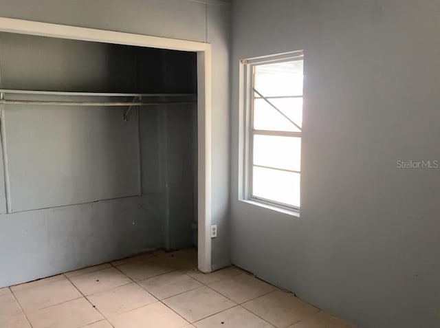 unfurnished bedroom with a closet and light tile patterned flooring