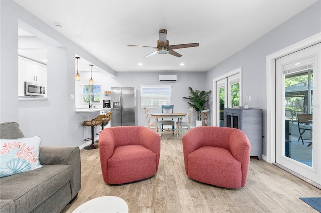 5421 Gay St, Weeki Wachee, FL 34607 - living area featuring a ceiling fan, recessed lighting, an AC wall unit, baseboards, and light wood-type flooring