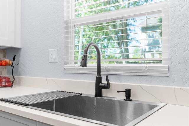 5421 Gay St, Weeki Wachee, FL 34607 - room details featuring a sink, a textured wall, light countertops, and white cabinets