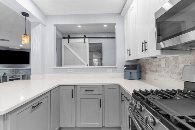 5421 Gay St, Weeki Wachee, FL 34607 - kitchen with recessed lighting, decorative light fixtures, a peninsula, decorative backsplash, and appliances with stainless steel finishes