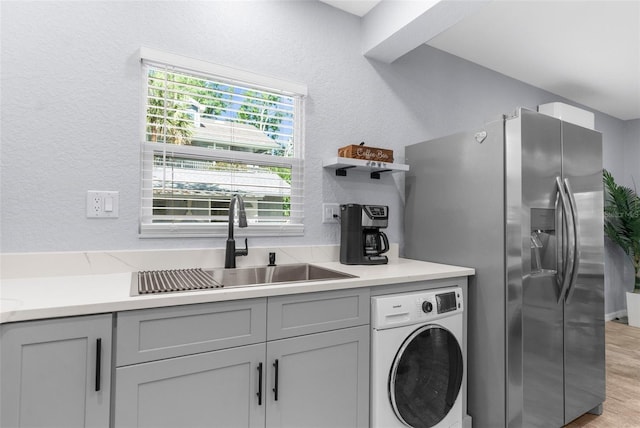 5421 Gay St, Weeki Wachee, FL 34607 - kitchen with a sink, stainless steel fridge with ice dispenser, gray cabinets, a textured wall, and washer / clothes dryer
