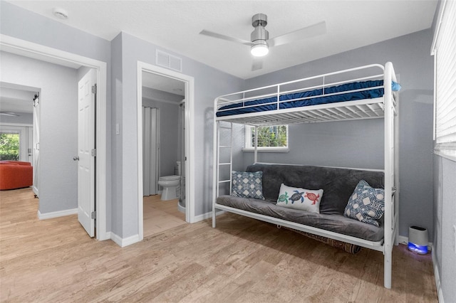 5421 Gay St, Weeki Wachee, FL 34607 - bedroom with baseboards, ceiling fan, visible vents, connected bathroom, and wood finished floors