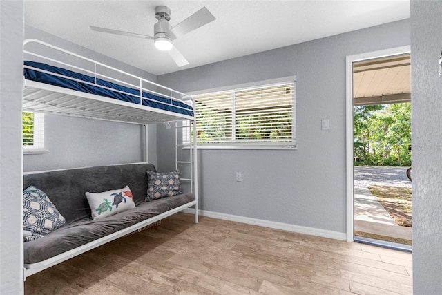 5421 Gay St, Weeki Wachee, FL 34607 - bedroom with access to outside, a ceiling fan, baseboards, and wood finished floors