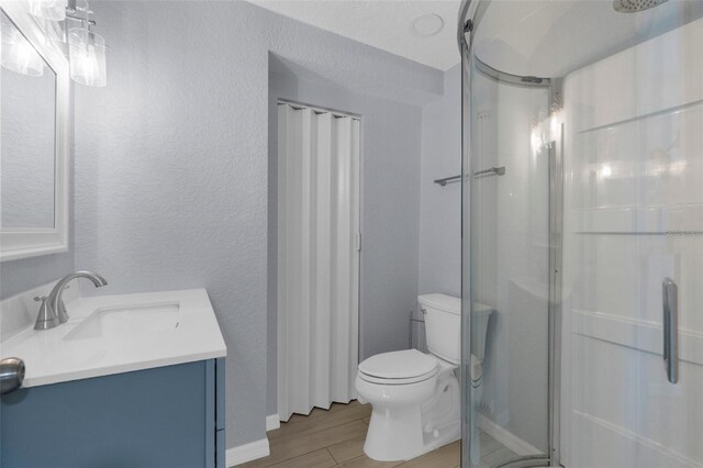 5421 Gay St, Weeki Wachee, FL 34607 - bathroom featuring a stall shower, toilet, vanity, wood finished floors, and a textured wall