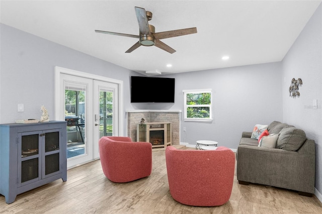 5421 Gay St, Weeki Wachee, FL 34607 - living room featuring a ceiling fan, a wealth of natural light, a brick fireplace, and wood finished floors