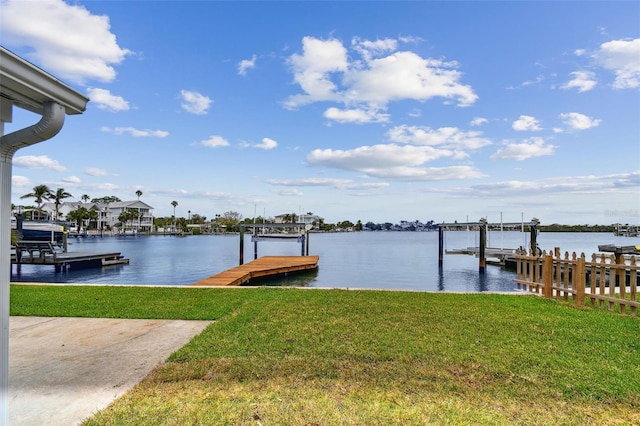dock area with a water view, a yard, and boat lift