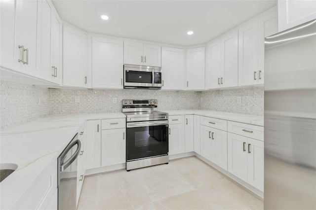 kitchen with stainless steel appliances, light stone countertops, white cabinetry, decorative backsplash, and recessed lighting