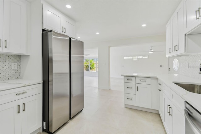 kitchen featuring appliances with stainless steel finishes, white cabinetry, ceiling fan, light stone countertops, and recessed lighting