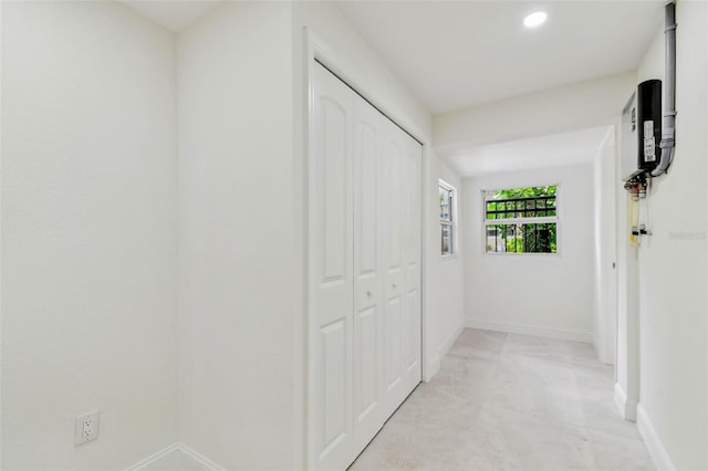 hall with baseboards and recessed lighting