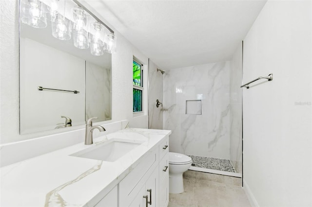 bathroom featuring a marble finish shower, toilet, and vanity