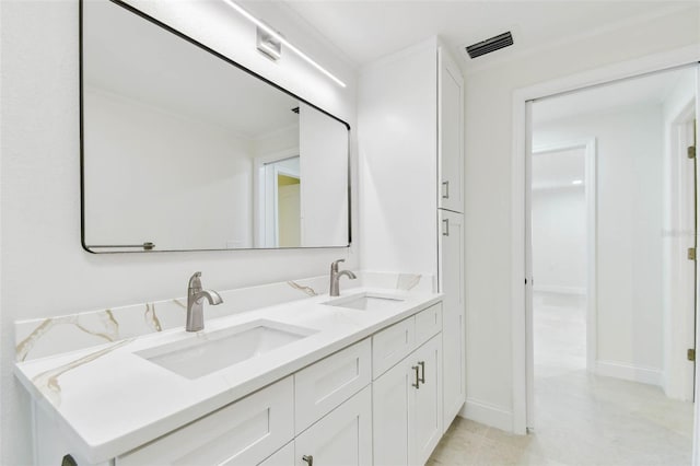 full bath with double vanity and baseboards