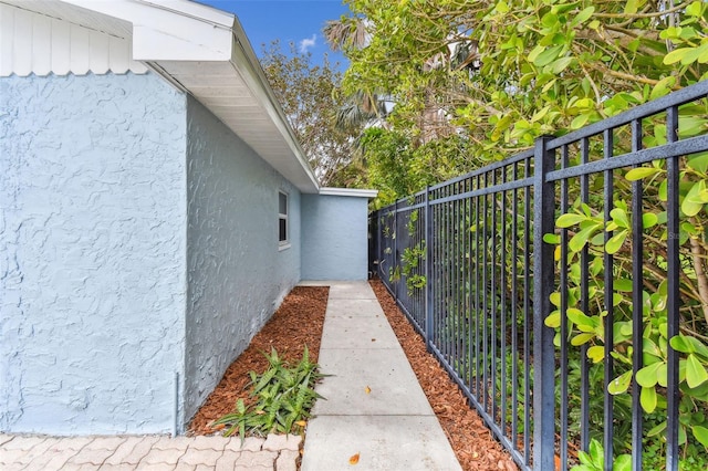 view of home's exterior featuring stucco siding and fence